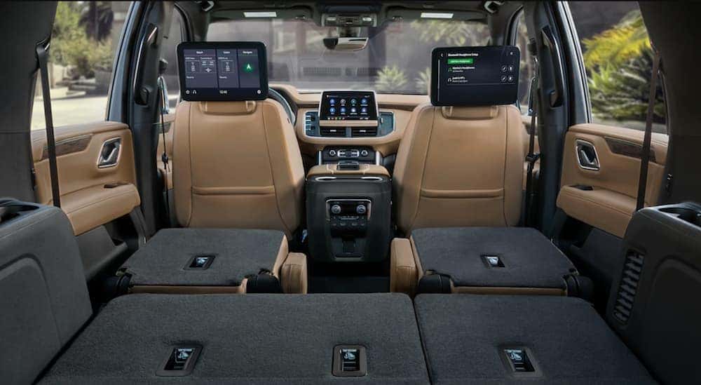 The tan leather rear seats are shown folded down in a 2021 Chevy Suburban. 