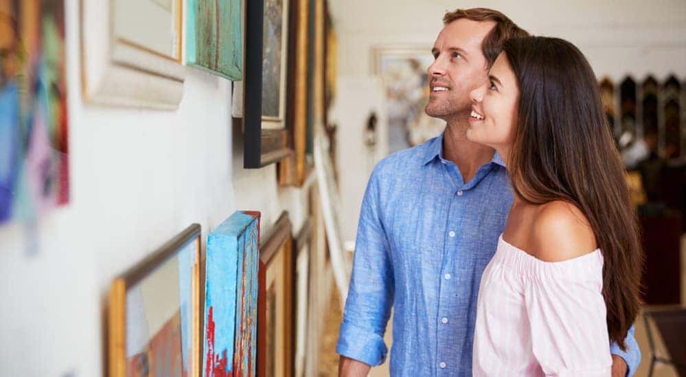 A smiling couple is looking at pictures in an art gallery near Dayton, Ohio.