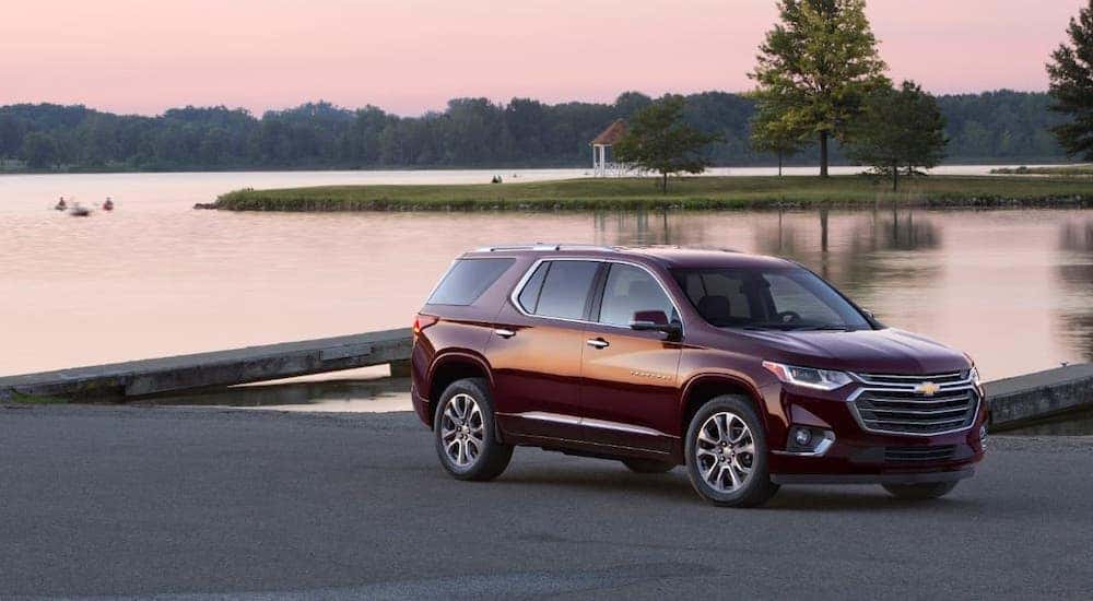 A burgundy 2018 Chevy Traverse is parked in front of pond at dusk.
