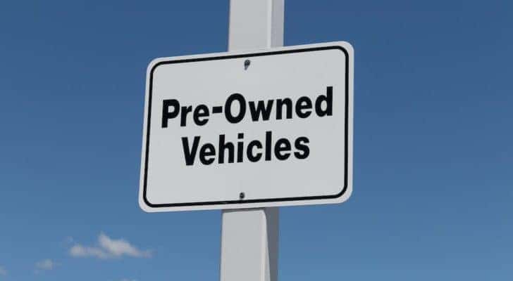 A white sign says 'Pre-owned Vehicles.'