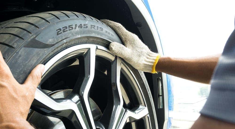 A gloved hand is changing the tire at a discount tire shop in Cincinnati.