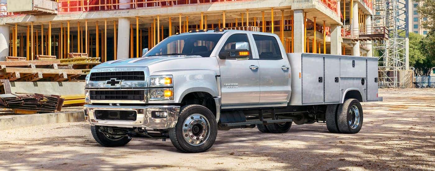 A silver 2020 Chevy Silverado 4500 HD is shown from the side on a construction site.