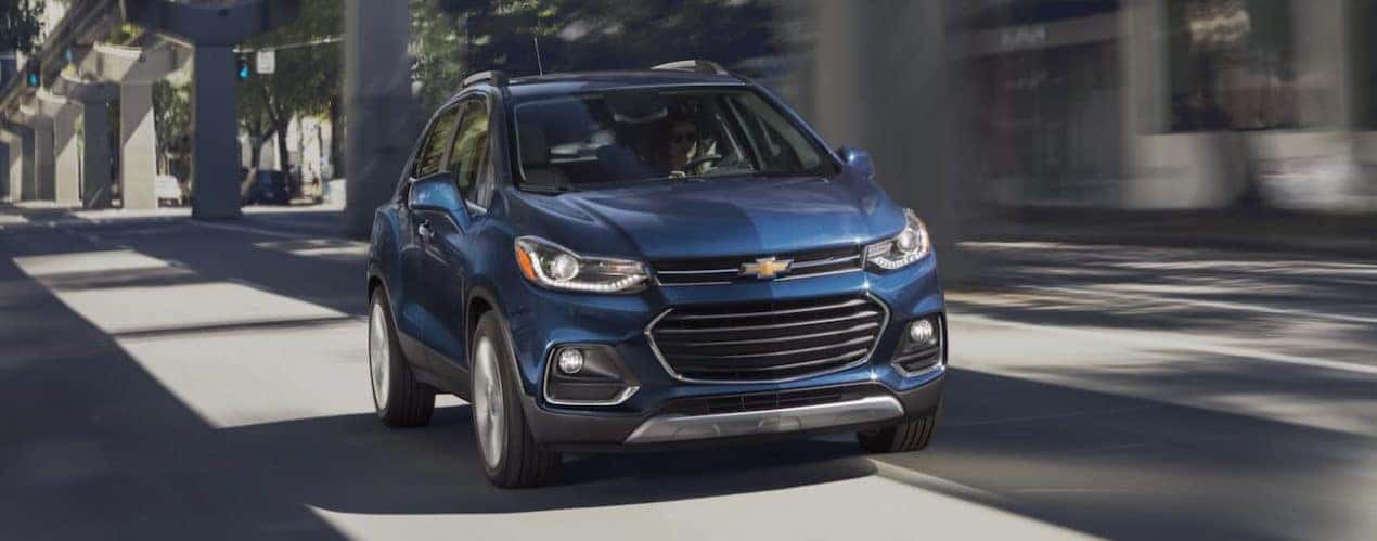 A blue 2020 Chevy Trax is driving on a city street near Cincinnati, OH.