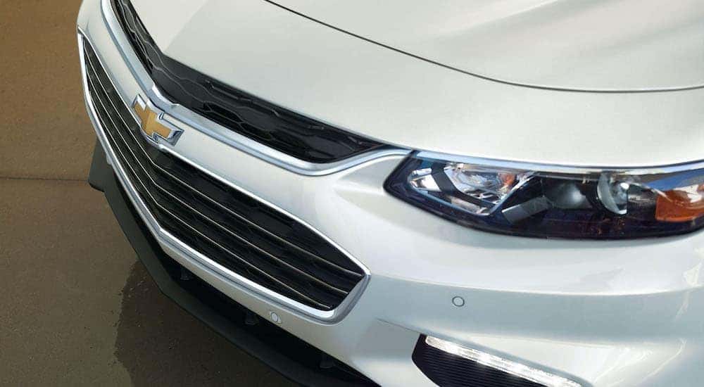 The front end of a white 2016 used Chevy Malibu is shown.