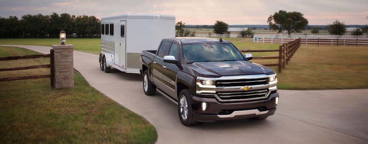 A black 2017 Chevy Silverado 1500 is towing an enclosed trailer.