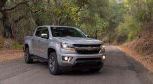 A silver 2018 Chevy Colorado is parked in the middle of a tree-line road after leaving a Kings Automall used car dealer.