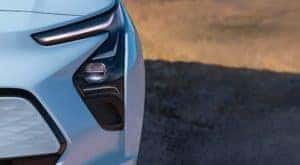 A close up shows the front headlight and DRL on a pale blue 2022 Chevy Bolt EV.