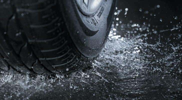 A set of good rain tires is shown in close up while shedding water.