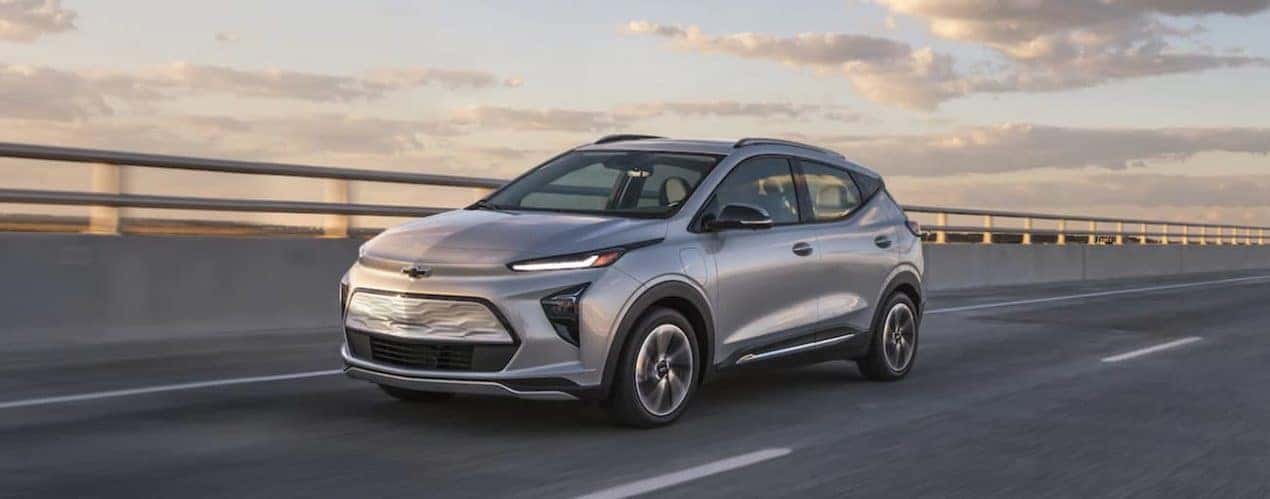 A silver 2022 Chevy Bolt EUV is driving alone on a highway after winning the 2022 Chevy Bolt EUV vs 2020 Kia Niro EV comparison.