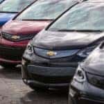 A row of Chevy vehicles in stock, 2017 Chevy Bolt EVs, are shown parked on pavement.