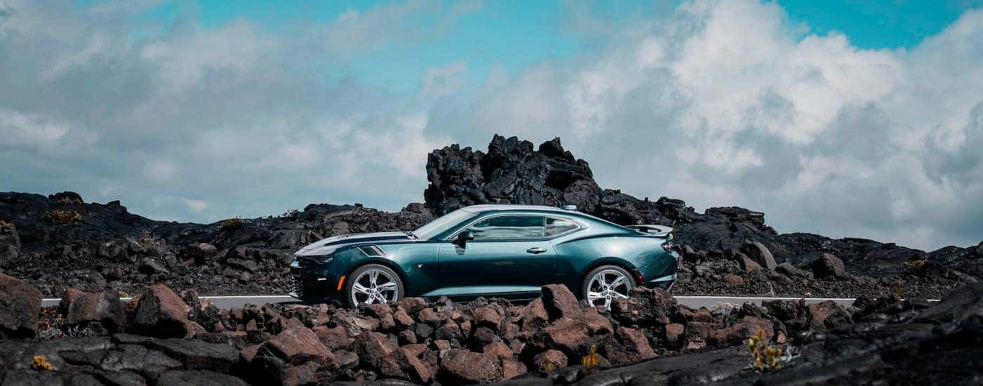 A blue 2021 Chevy Camaro SS is shown from the side parked near rock formations.