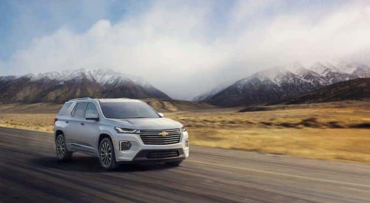 A silver 2022 Chevy Traverse is shown driving on a highway.