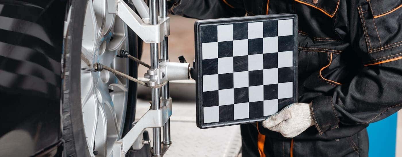 A close up shows an alignment target attached to a wheel.