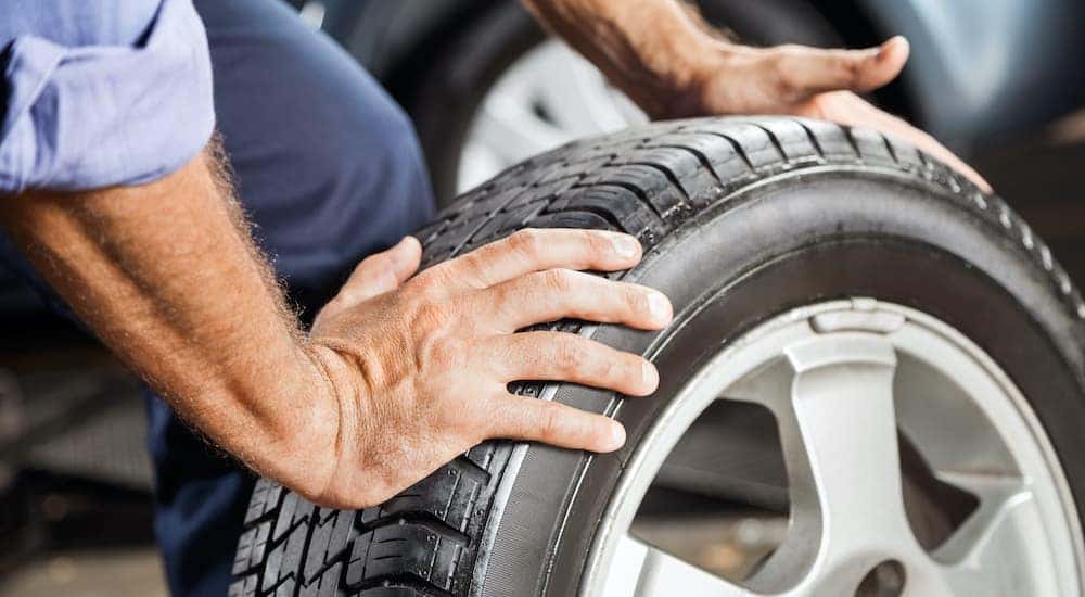 A person is rolling a tire after finding the best tires in Cincinnati.