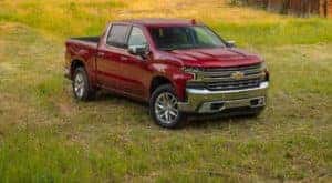 A red 2020 Chevy Silverado 1500 is shown parked in a field after leaving a Cincinnati used truck dealership.