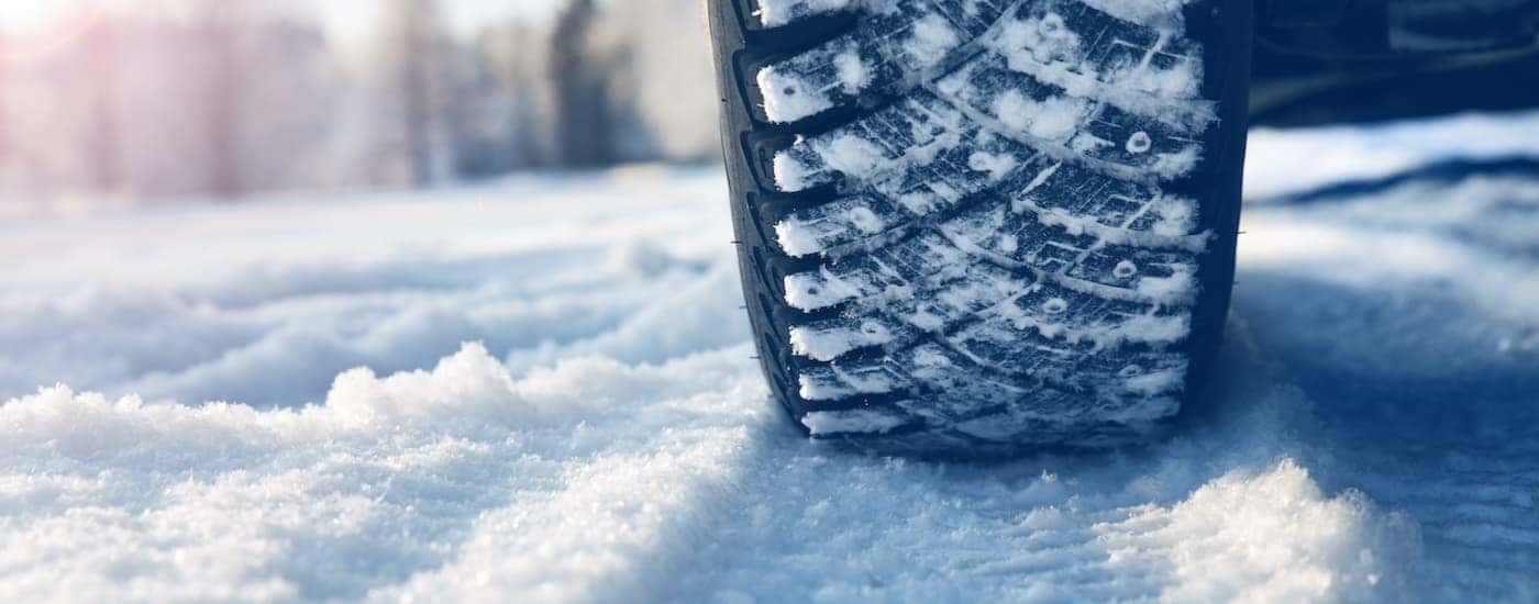 A tire is shown driving in the snow.