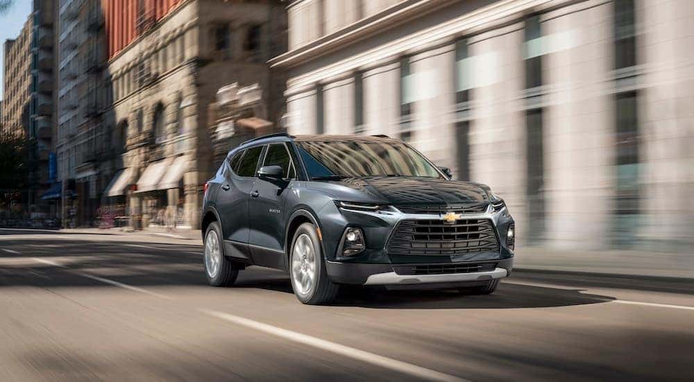A black 2021 Chevy Blazer is shown driving on a city street on the way to one of the most popular Chevrolet dealers in KY, McCluskey Chevrolet.