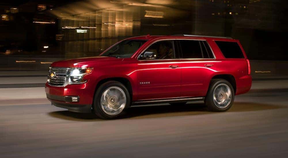 A red 2020 Chevy Tahoe is shown from the side driving at night.