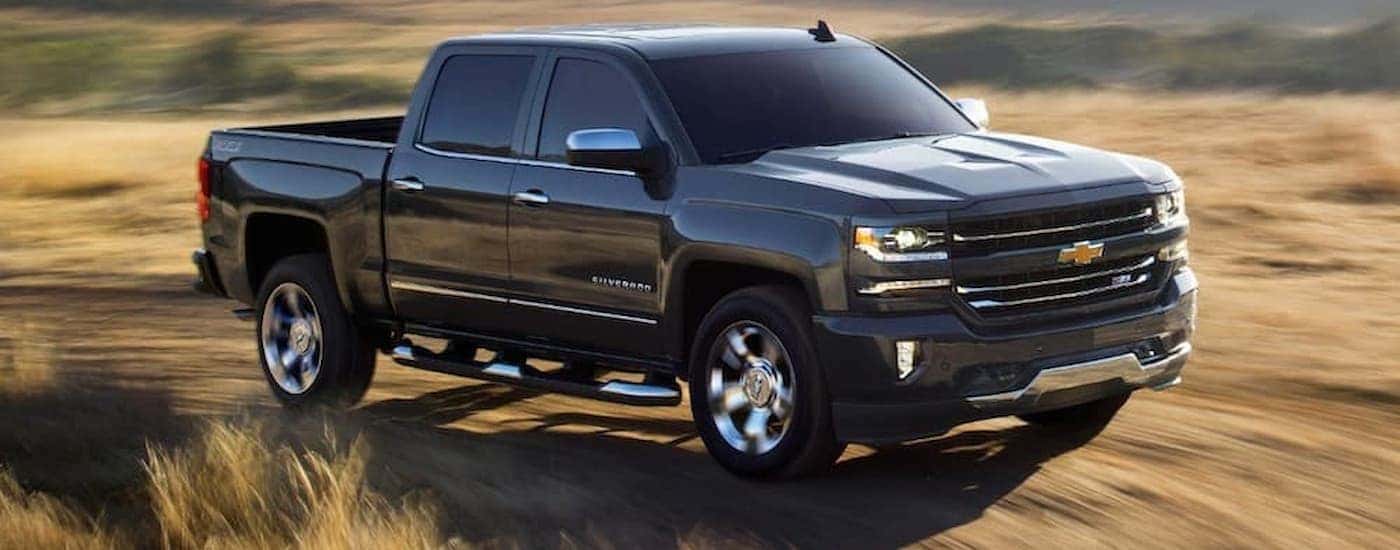 A black 2018 Chevy Silverado 1500 is shown on a dry grassy trail.