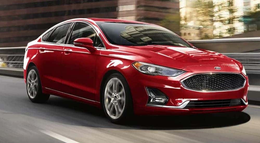 A red 2020 Ford Fusion is shown leaving used car lots in Cincinnati, Ohio.
