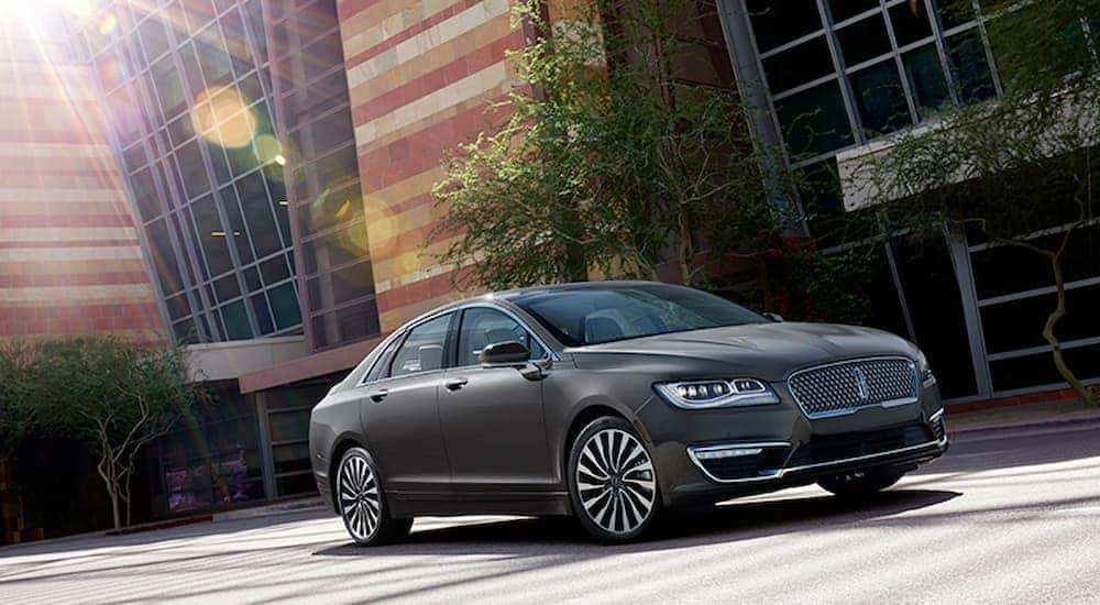 A grey 2017 Lincoln MKZ is shown in front of a brick building.