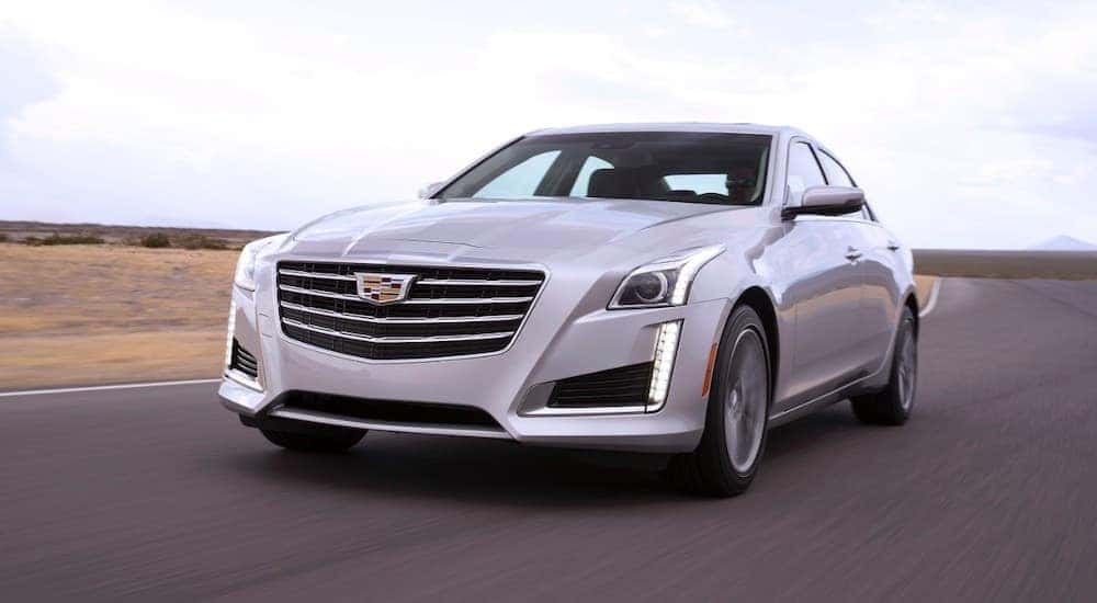 A silver 2018 Cadillac CTS is shown driving on an open road.