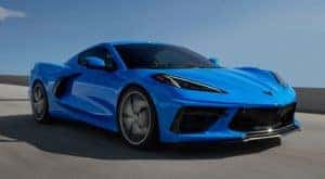 A blue 2022 Chevy Corvette is shown driving on a highway after leaving a Cincinnati C8 Corvette dealer.