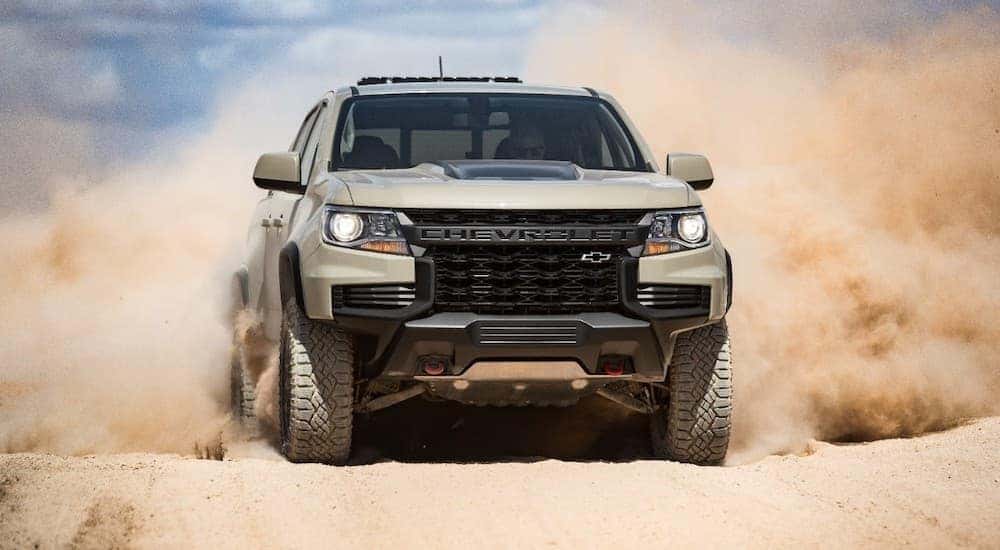 A tan 2021 Chevy Colorado ZR2 is shown from the front while it drives through the desert.