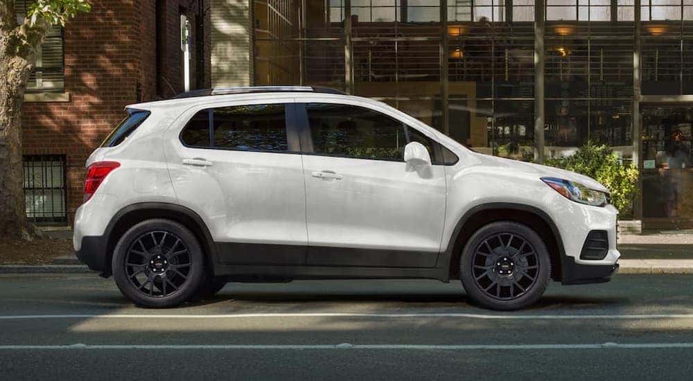 A white 2022 Chevy Trax is shown from the side while parked on a city street