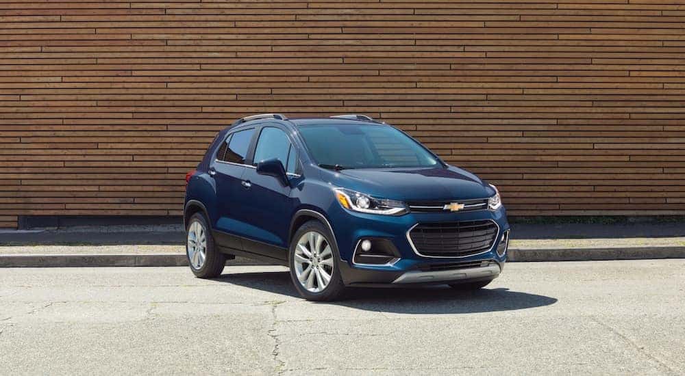 A blue 2022 Chevy Trax is shown from the front at an angle while parked in front of a building.