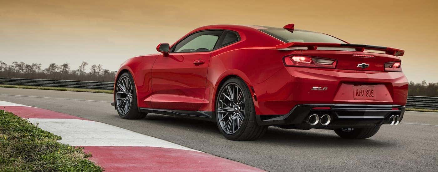 A red 2017 Chevy Camaro ZL1 is shown from behind on a race track.