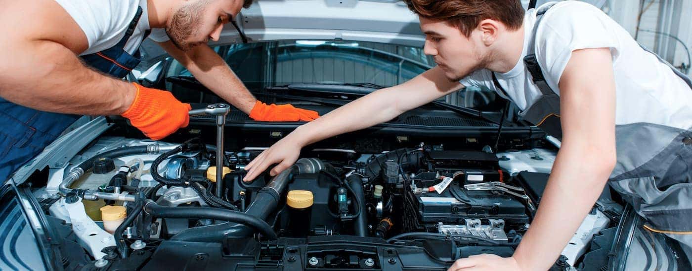 Two mechanics are shown servicing a used car in Cincinnati.