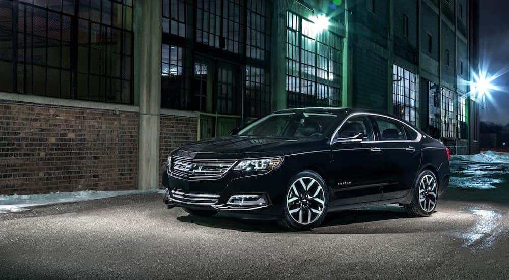 A black 2018 Chevy Impala Midnight Edition is shown parked on a city street at night.