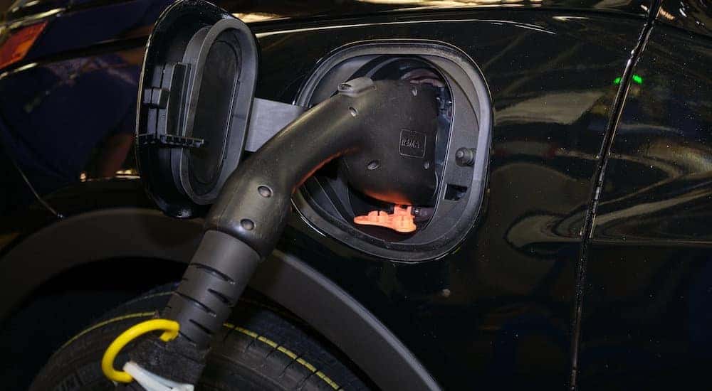 A charge cable is shown plugged into the charge port of a black 2022 Chevy Bolt EV.