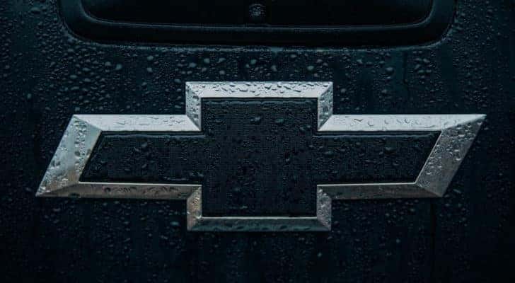 A black Chevy logo is shown covered in dew drops.