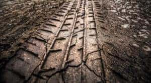 An off-road tire track is shown in the mud.