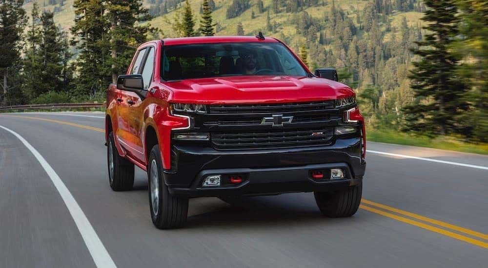 A red 2020 Chevy Silverado 1500 LT is shown from the front driving on an open road.