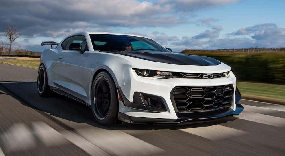 A white 2021 Chevy Camaro ZL1 is shown from the front at an angle while driving.