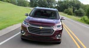 A maroon 2018 Chevy Traverse is shown from the front driving on an open road.
