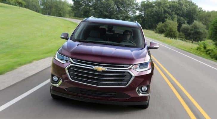 A maroon 2018 Chevy Traverse is shown from the front driving on an open road.