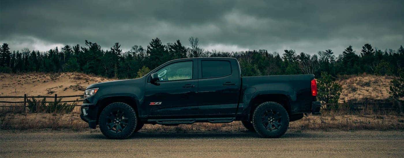 A black 2018 Chevy Colorado Z71 is shown from the side on a dirt trail.