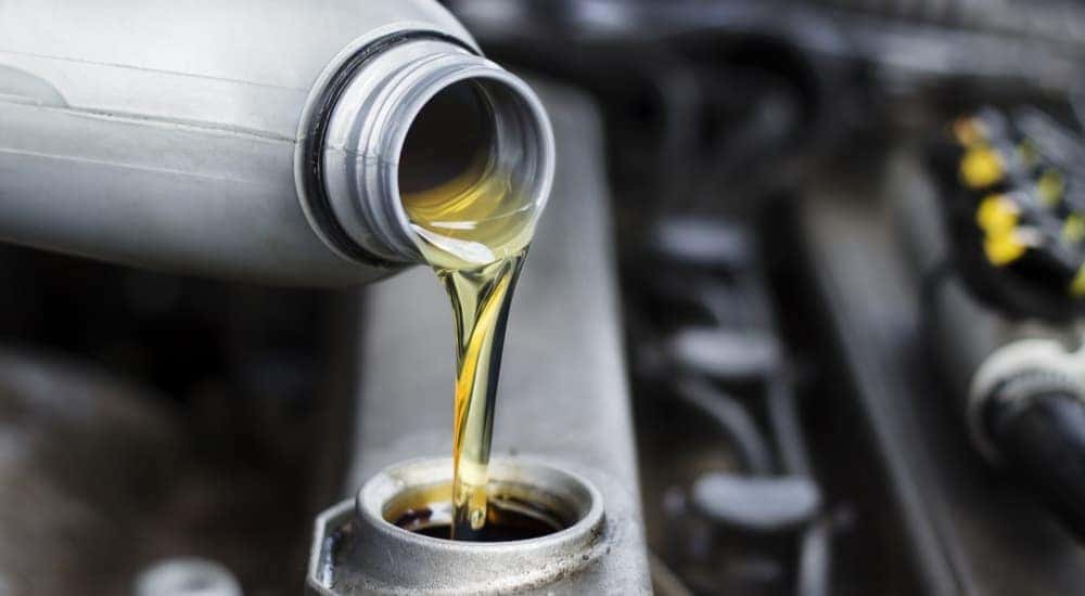 Oil is shown being poured into an engine.