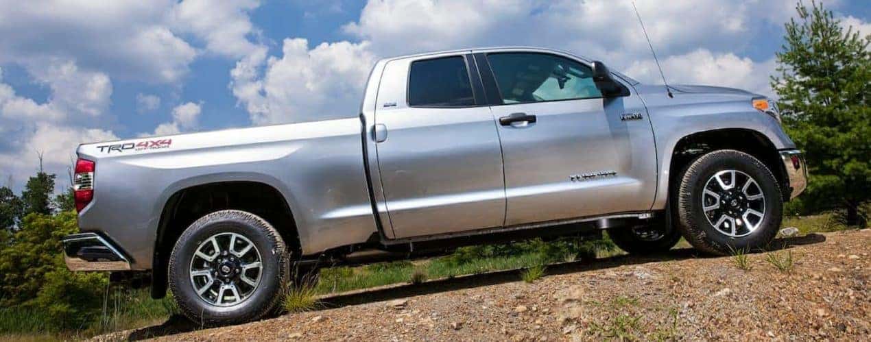 A silver 2015 Toyota Tundra is shown driving through an off-road trail.