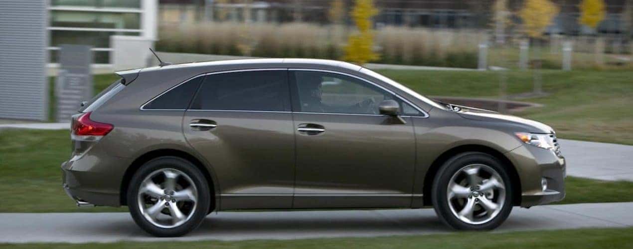 A brown 2009 Toyota Venza is shown from the side driving on a street.