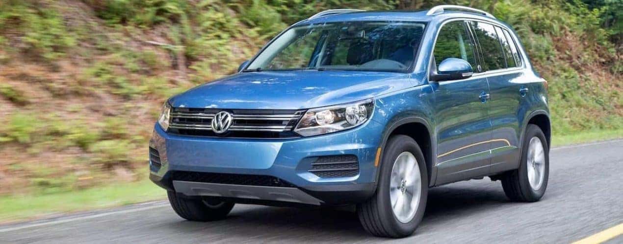 A blue 2017 Volkswagen Tiguan is shown driving on an open road.