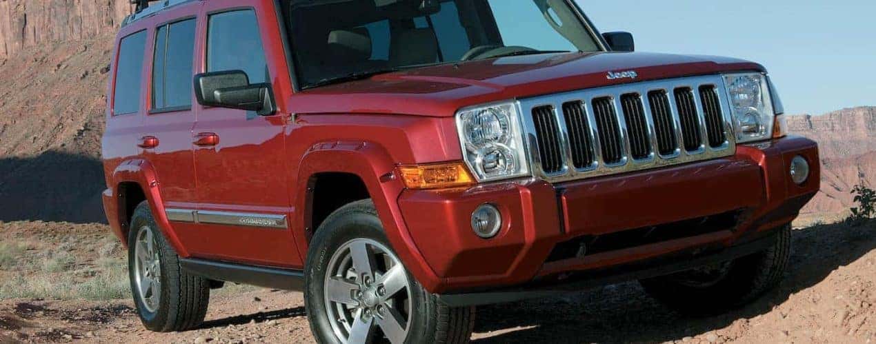 A red 2008 Jeep Commander is shown on a desert path.