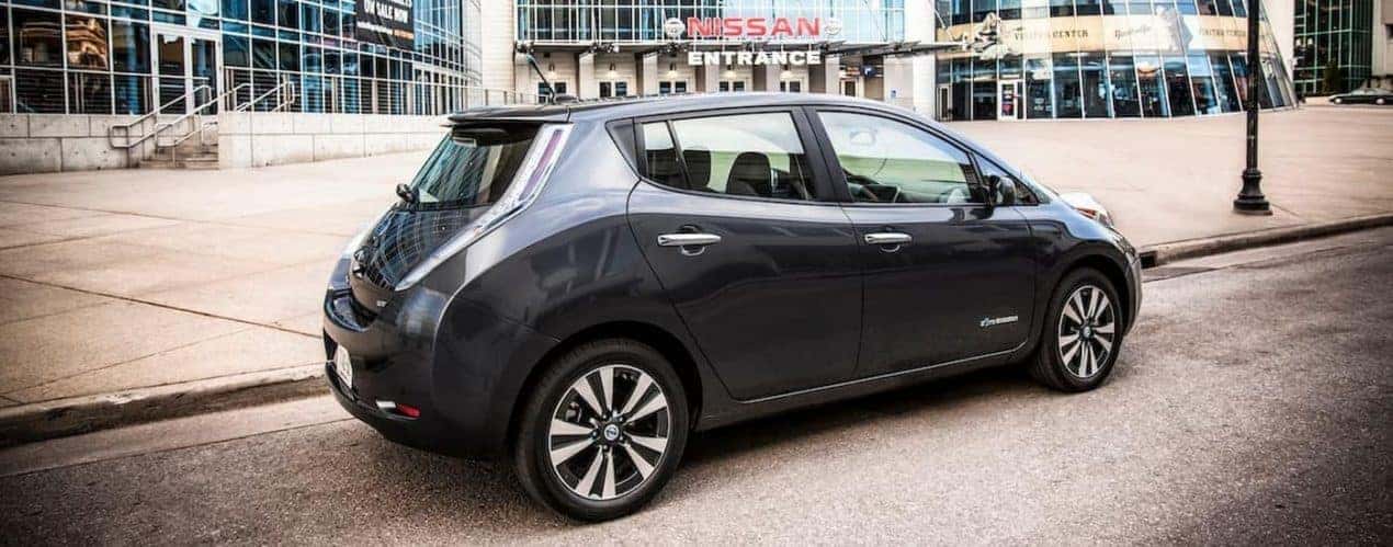 A black 2013 Nissan Leaf is shown from the side parked on a city street.