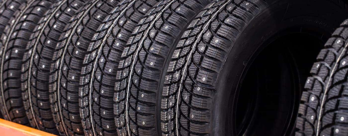 A row of studded snow tires are shown at a tire shop.