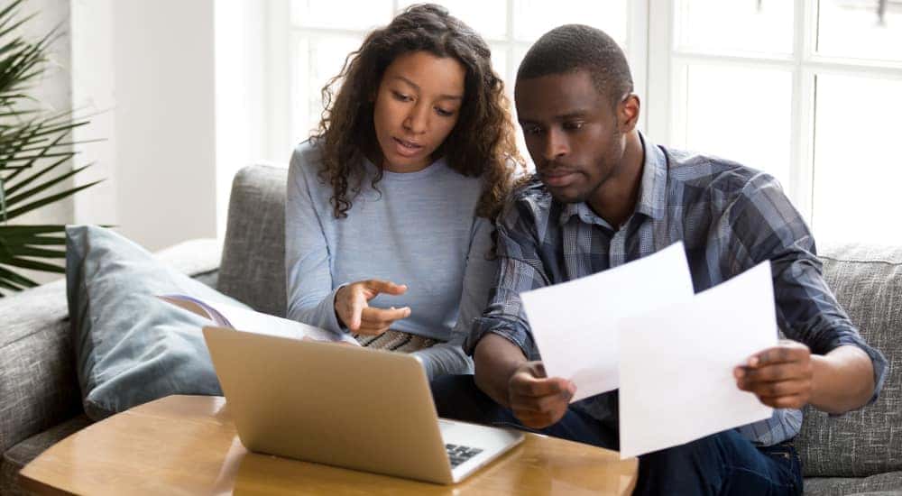 A couple is shown looking at a laptop looking for a buy here pay here dealership.
