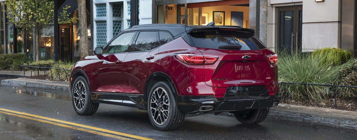 A red 2023 Chevy Blazer RS is shown from the rear parked in front of a building.